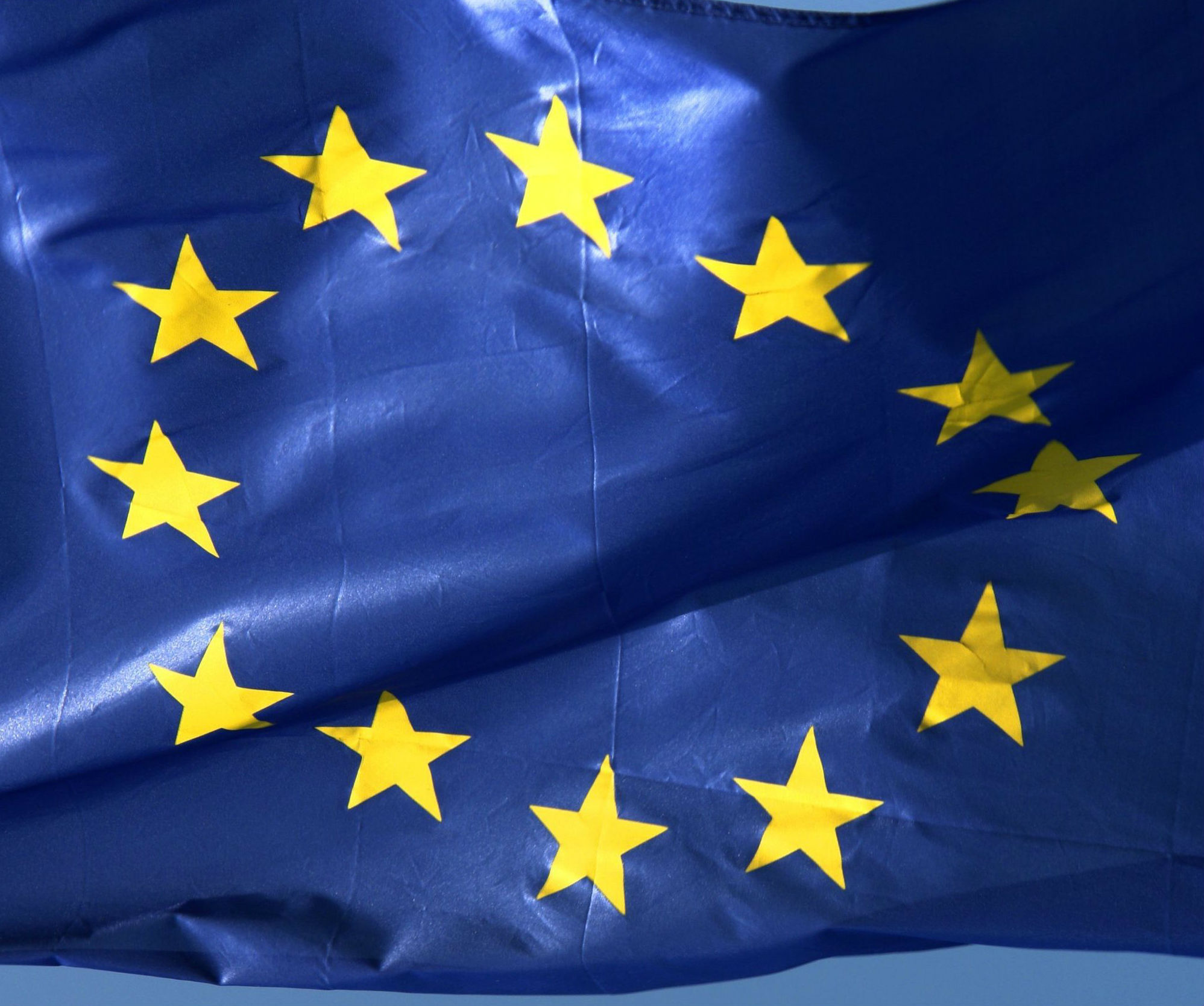 Foto av EU-flagget, med tolv gylne stjerner i sirkel på mørkblå bunn.