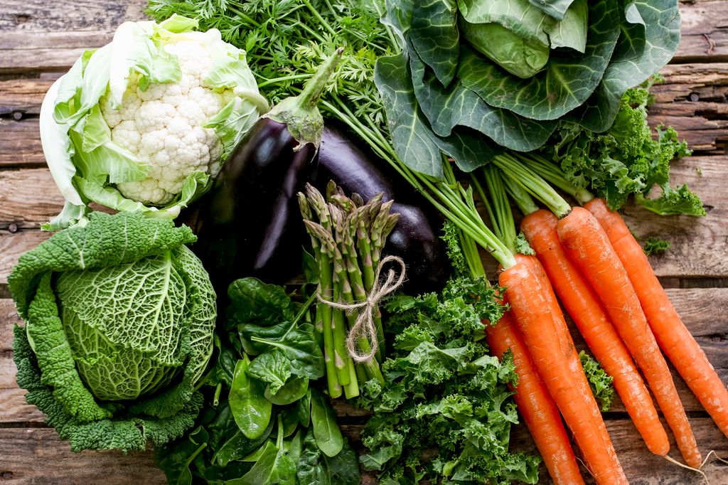 Ulike sorter grønnsaker med en bakgrunn av treplanker. Foto.