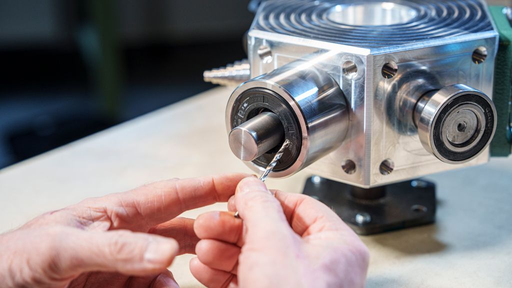 Mekanisk del der det bores hull i en sirkulær gummipakning. Foto.