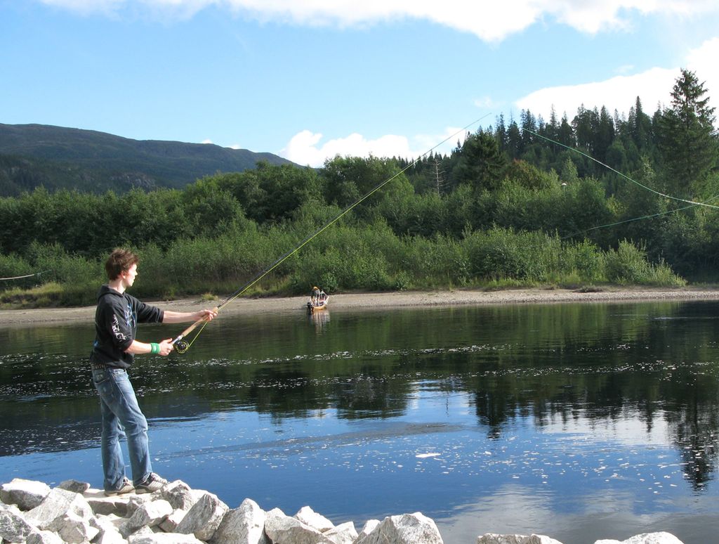 Gutt med fiskestang ved Namsenvassdraget. Foto.