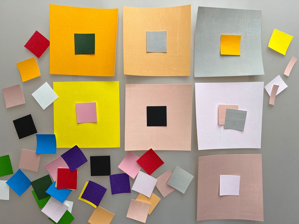 Små og store kvadratiske papirbiter i forskjellige farger. Foto.