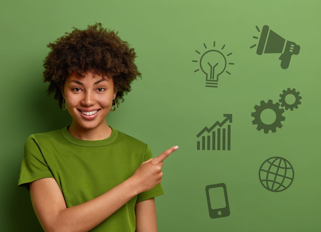 Smilende jente peker på ulike ikoner innen kommunikasjon: ropert, lyspære, tannhjul, stigende graf, globus og mobiltelefon. Foto.