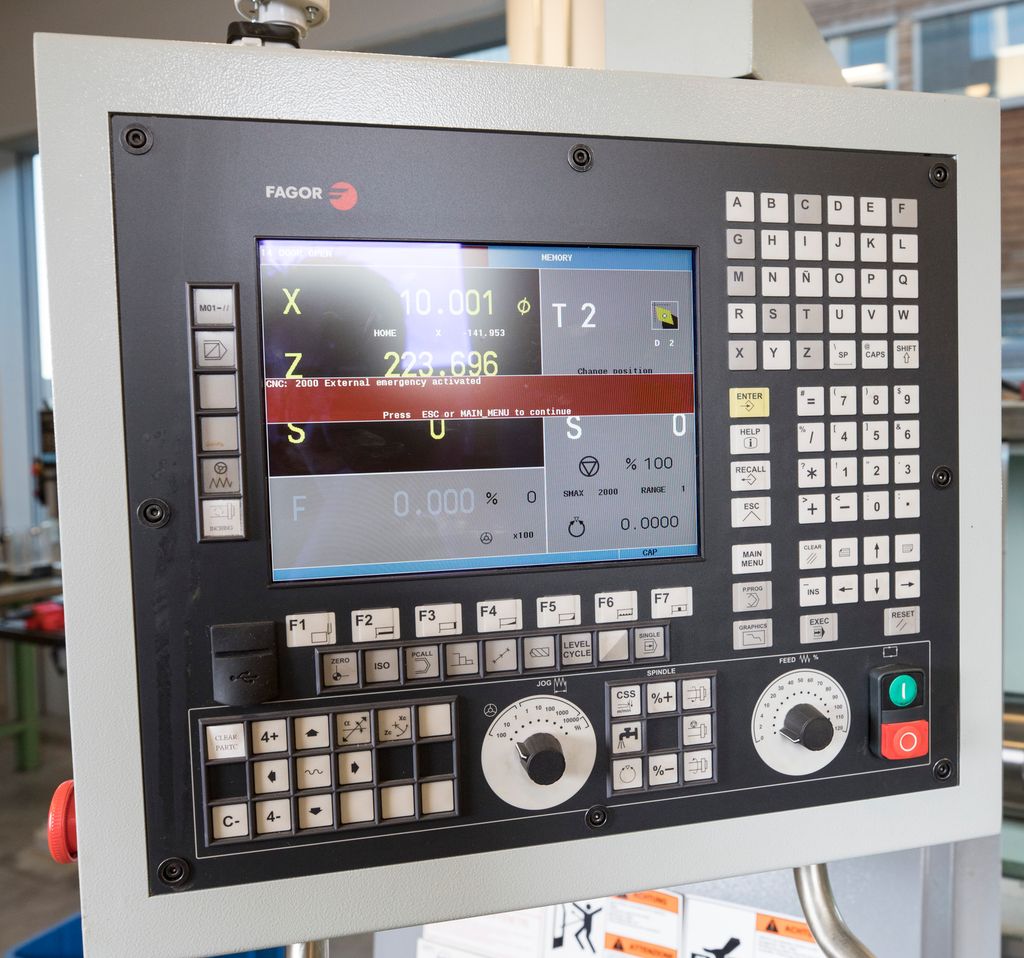 Programmeringsskjerm for CNC-styrt dreiebenk. Digital skjerm med ei rekke knappar og brytarar rundt. Foto.