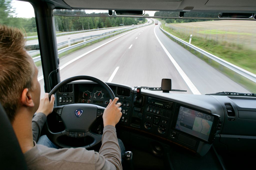 En lastebilsjåfør kjører på en motorvei. Foto.