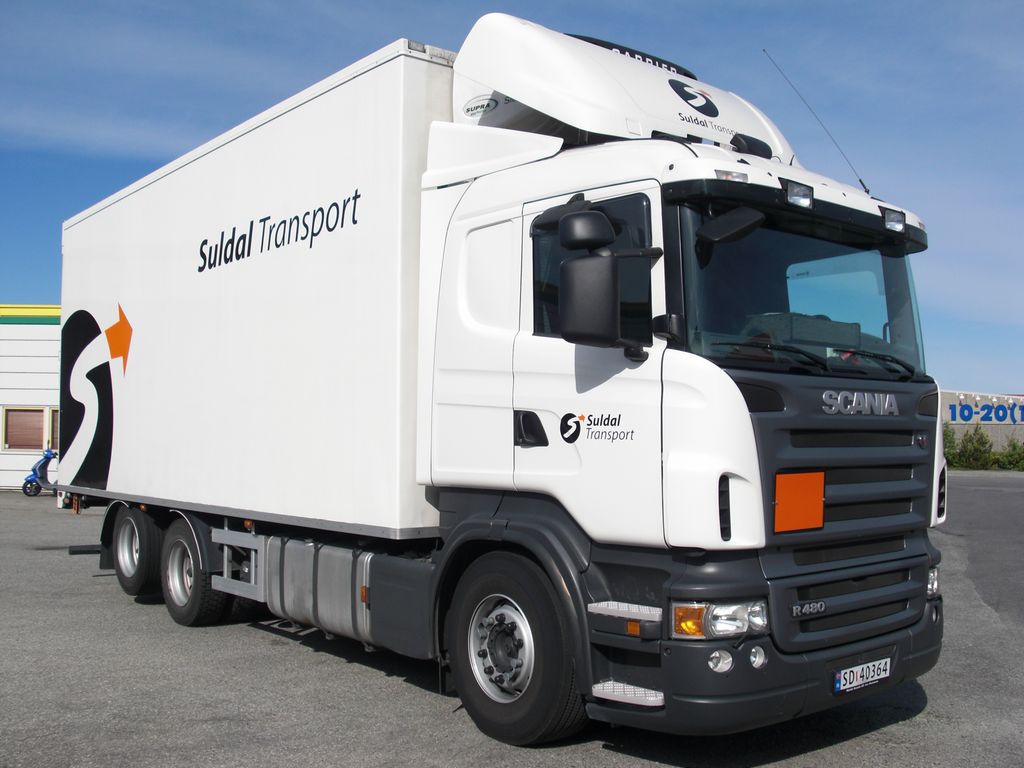 Bil med oransje skilt. Foto.