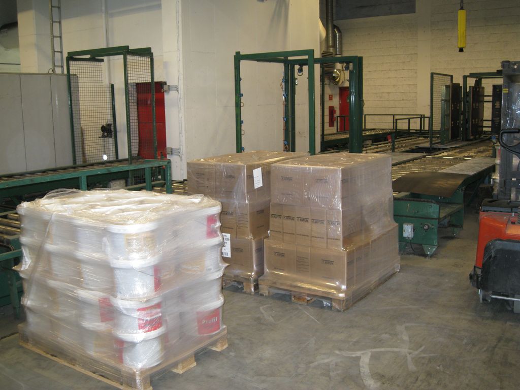 På bildet ser vi en europall med malingsspann med strekkfilm surret rundt. De andre to pallene har kartonger/esker med krympefilm rundt. Foto.