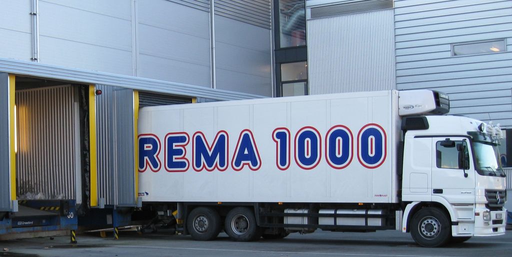 Hvit Rema1000 lastebil som står ved ei lasterampe. Foto