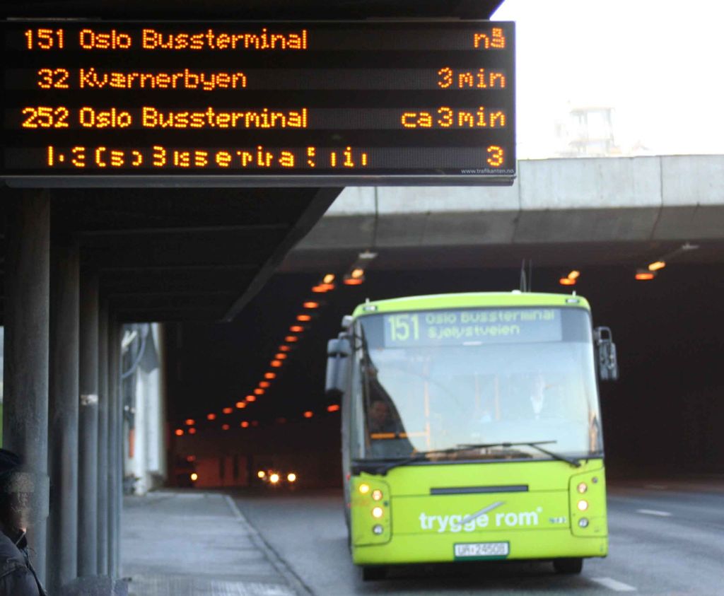 Buss som kommer ut av en tunnel og kjører inn til en holdeplass. Foto.