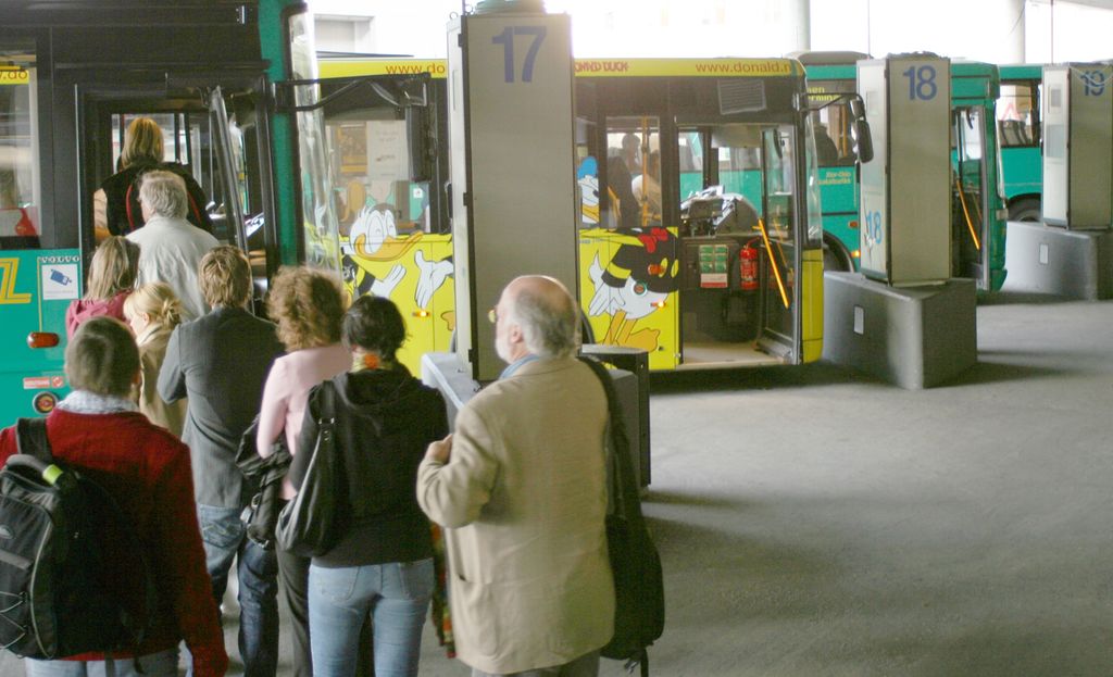Busspassasjerer på vei inn i en buss. Foto.
