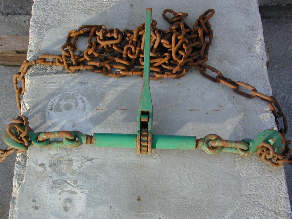 Langlenket kjetting på ei betongblokk. Foto.