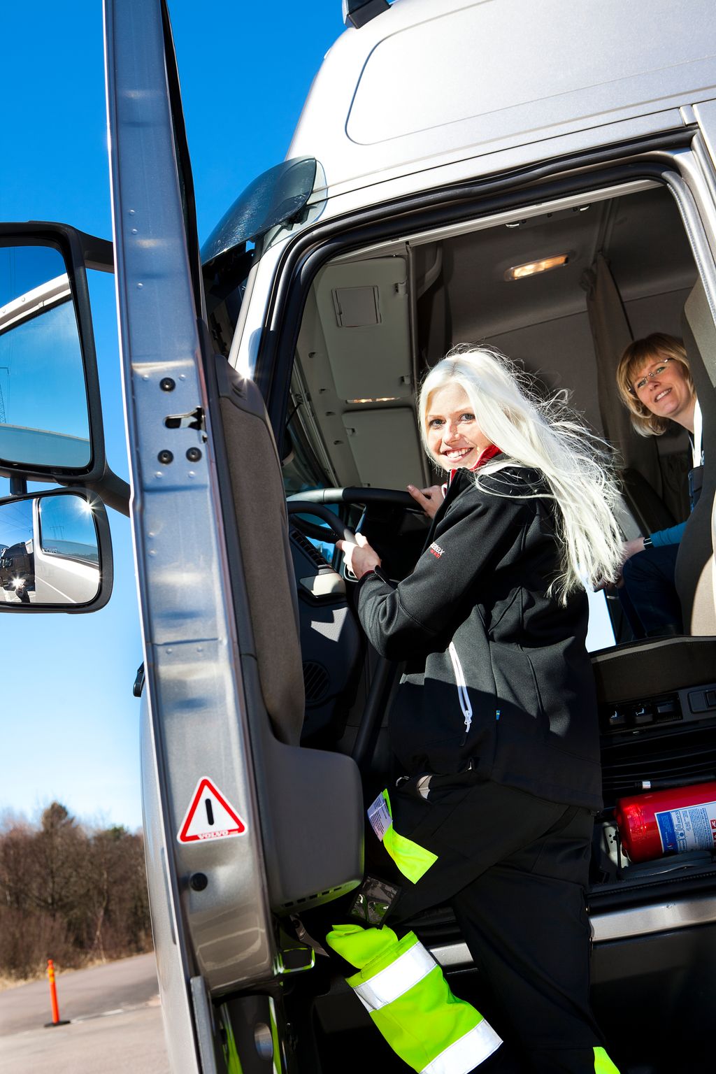 Bildet viser en lastebilsjåfør mens hun går inn i lastebilen. Foto.
