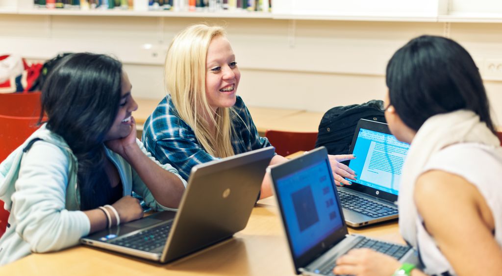 Three girls work together. Each girl has a computer. Photo.
