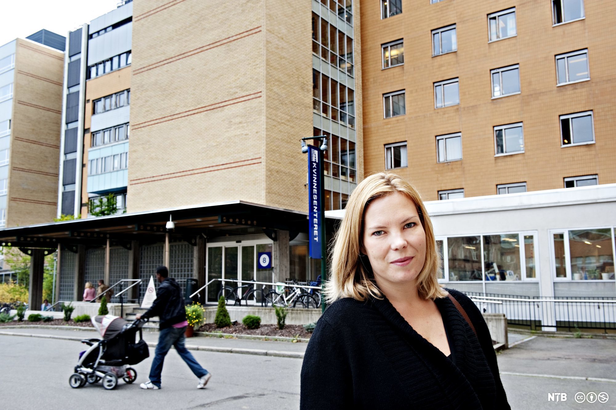 Marta Breen står utenfor et sykehus. Hun ser i kamera. Foto.