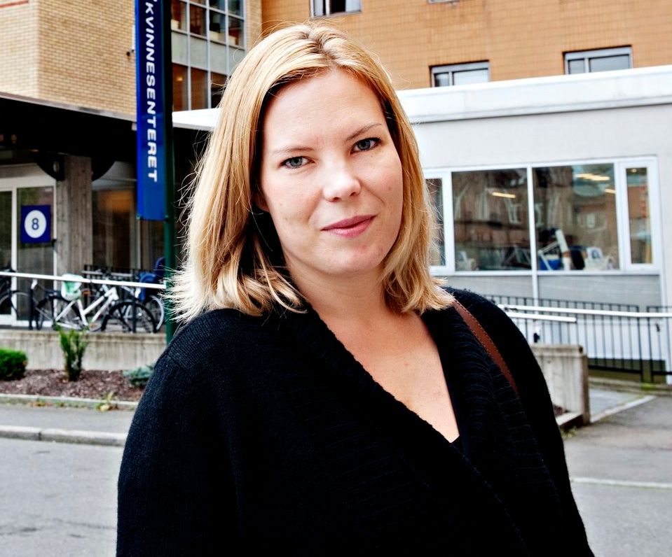 Marta Breen står utenfor et sykehus. Hun ser i kamera. Foto.