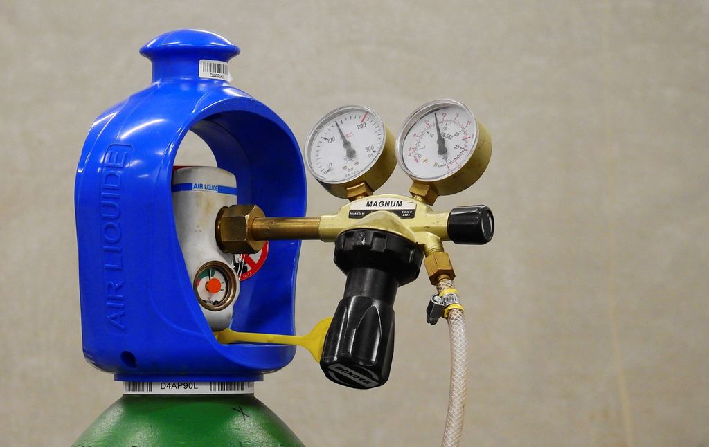Gassflaske med trykkventil og trykkmålere. Foto.