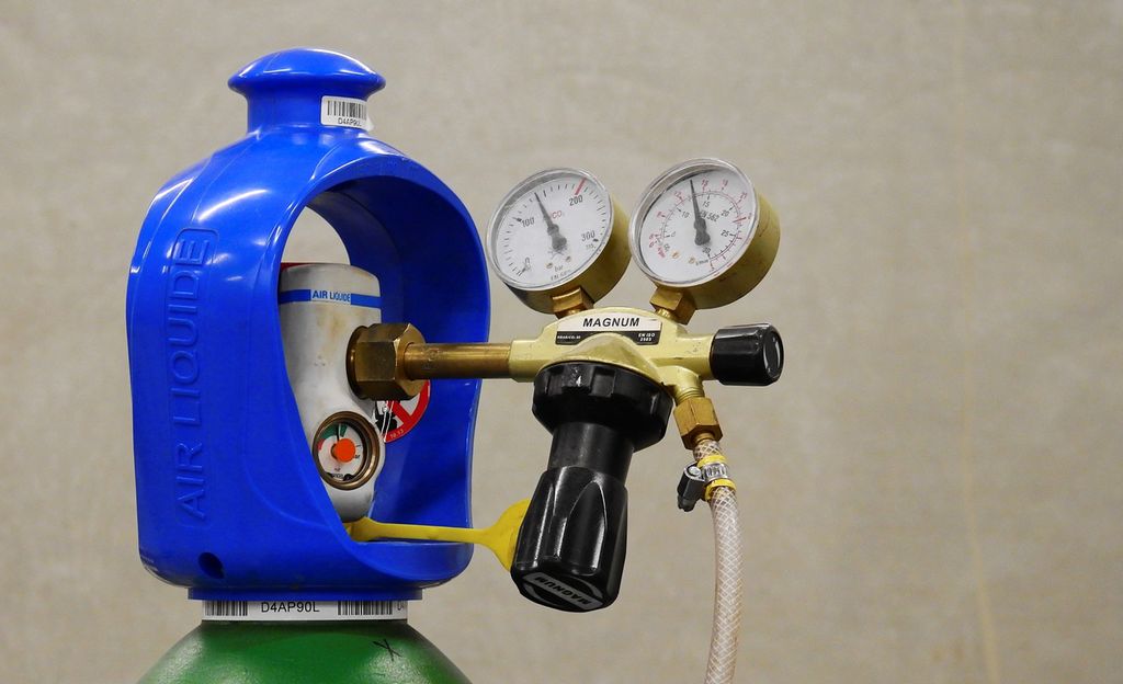 Gassflaske med trykkventil og trykkmålarar. Foto.