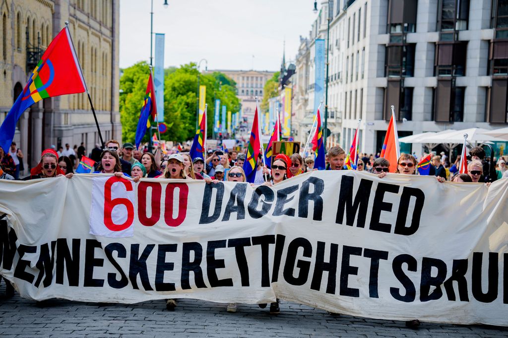 Aksjonister på Karl Johans gate. De har samiske flagg og et stort banner der det står "600 dager med menneskerettighetsbrudd". Foto.