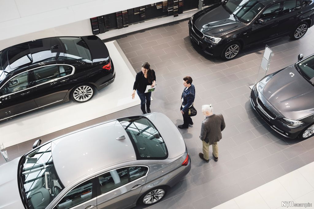 Flere personer ser på flotte biler i en bilutstilling. Foto. 