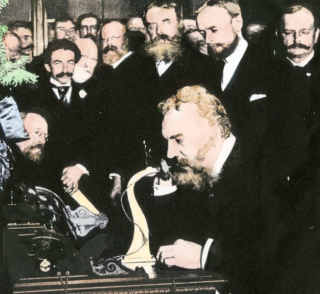 Graham Bell snakkar i telefon for fyrste gong. Handkollorert fotografi.