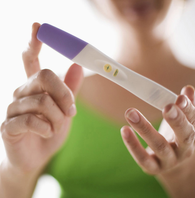 Foto av jente som ser på resultatet etter å ha tatt en graviditetstest