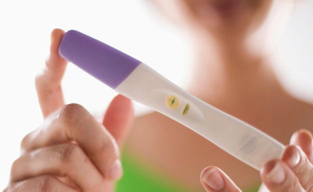 Foto av jente som ser på resultatet etter å ha tatt en graviditetstest