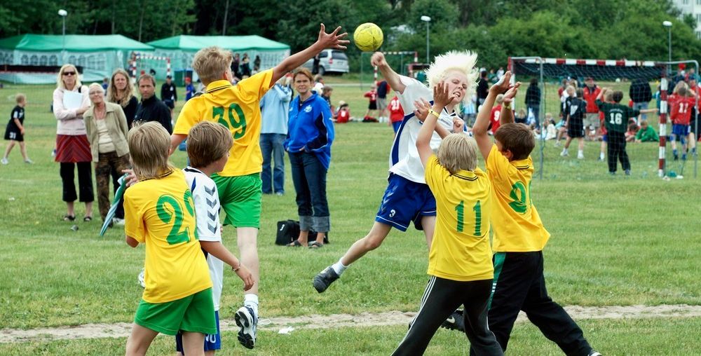 Gutter spiller håndball ute på gressplen. Foto.