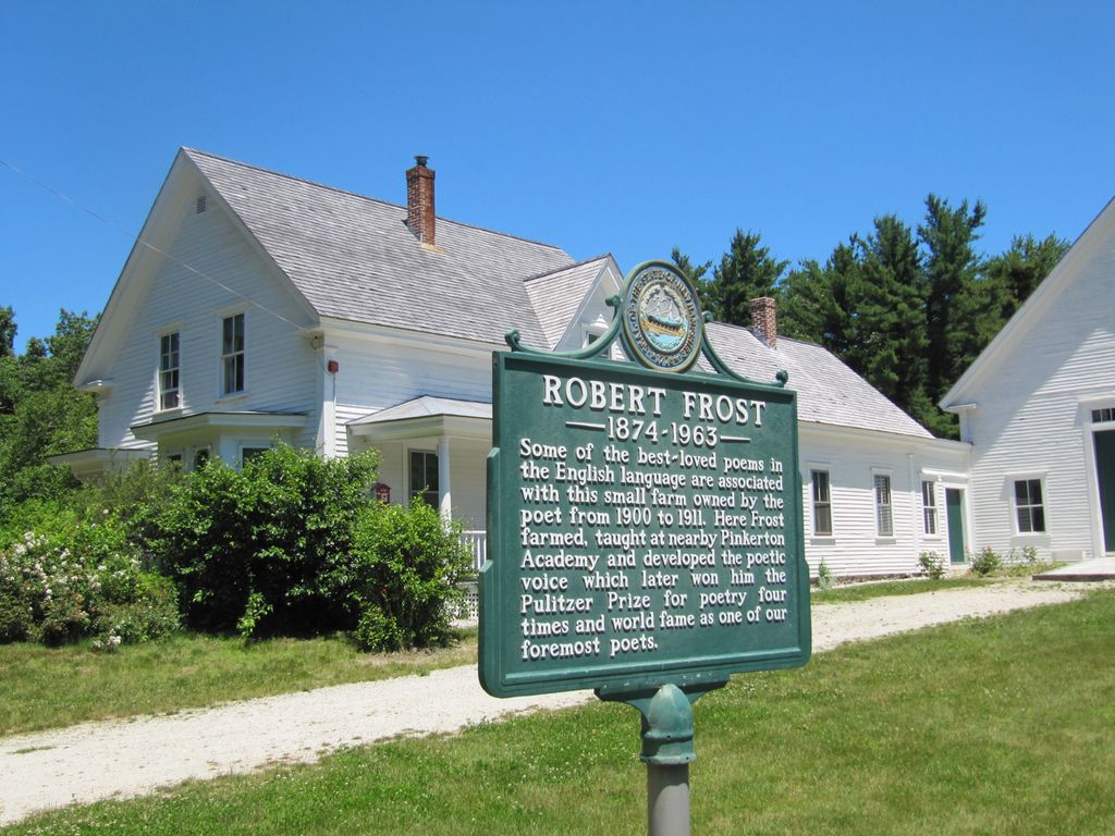 Sign on a lawn outside a white house. The sign says that Robert Frost owned this farm in New Hampshire from 1900 to 1911. Photo.