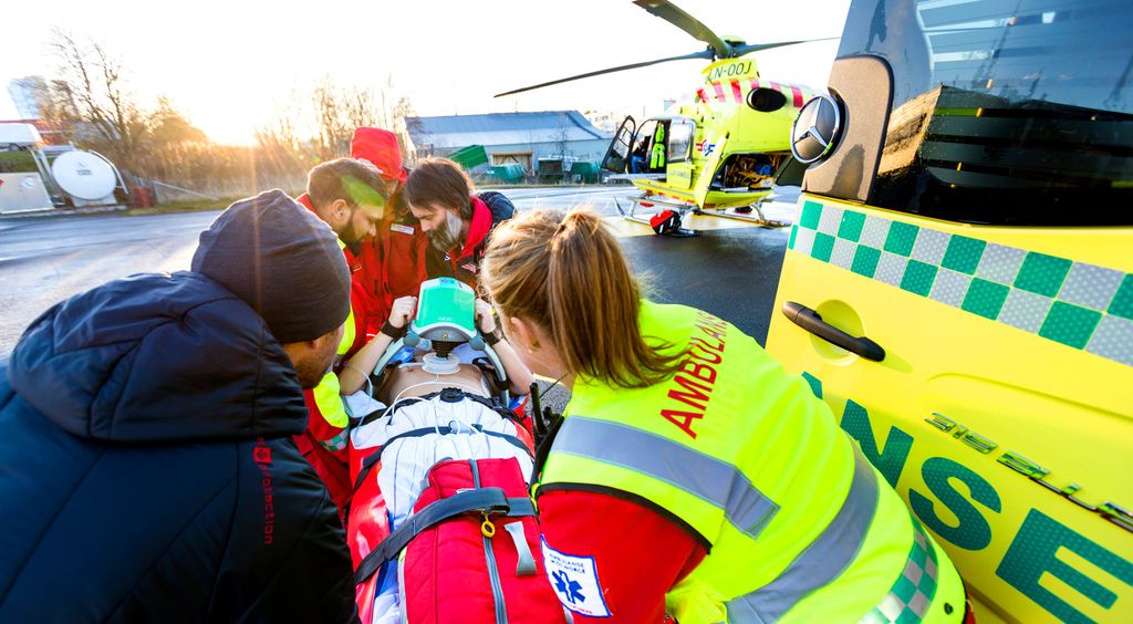 Pasient lastes inn i helikopter. Foto.