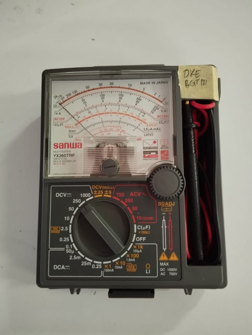 Elektrisk måleapparat med viser, vrider og ledninger. Foto.