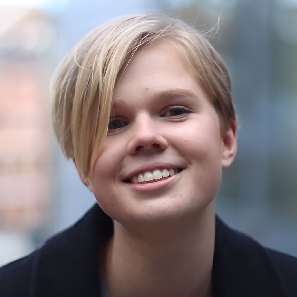 Portrett av elev Emilie Byermoen. Hun har lyst, relativt kort hår og sideskill, og har på seg lyseblå t-skjorte og sort jakke. Hun smiler. Foto.