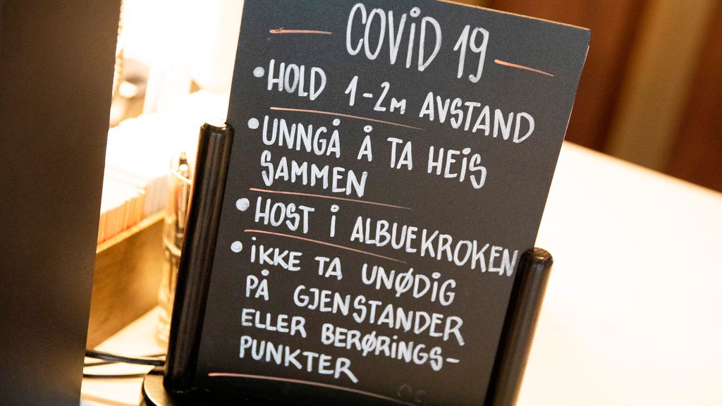 Svart tavle med informasjon om Covid 19. Tavla inneheld fire punkt: 1. Hald 1–2 meter avstand 2. Unngå å ta heis saman 3. Host i albuekroken 4. Ikkje ta unødig på gjenstandar eller berøringspunkt. Foto.