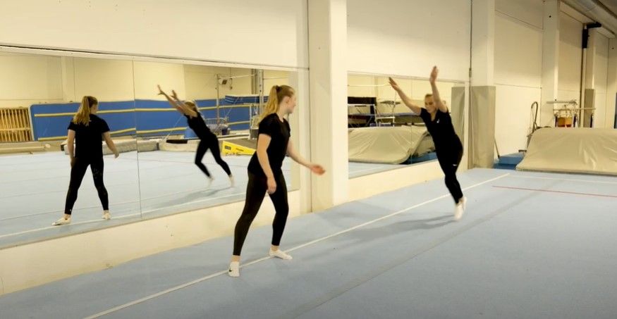 Jente som prøver å slå stiften, og ei annen jente som står klar til å støtte henne. Foto.