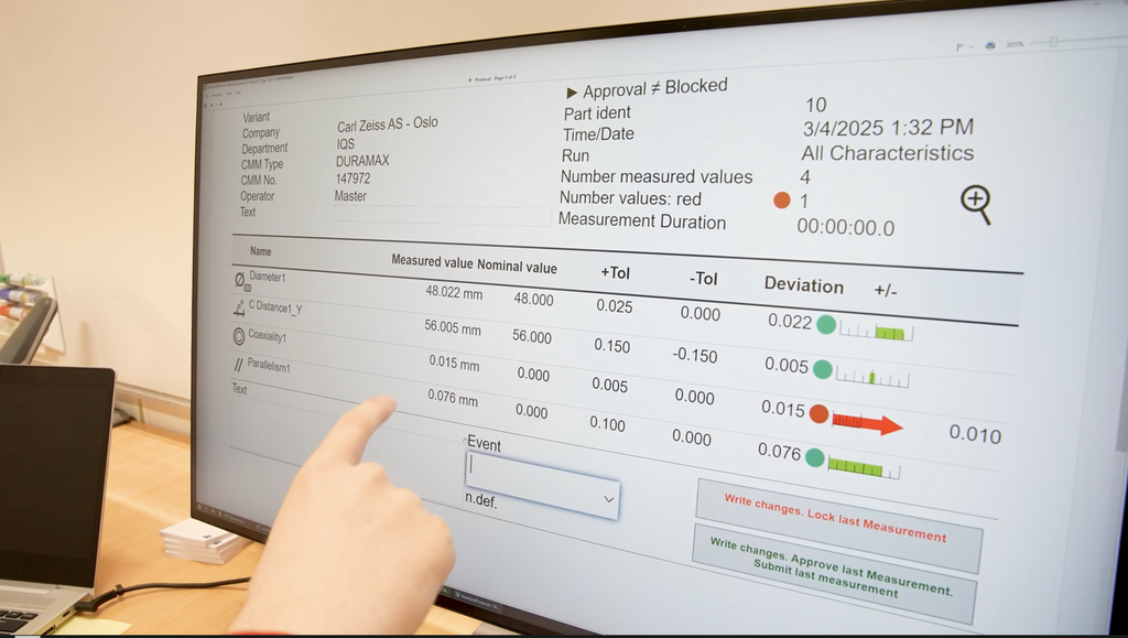Hånd som peker på en dataskjerm med måleverdier. Foto.
