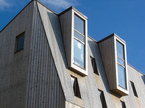 Moderne trebygning mot blå himmel. Foto.