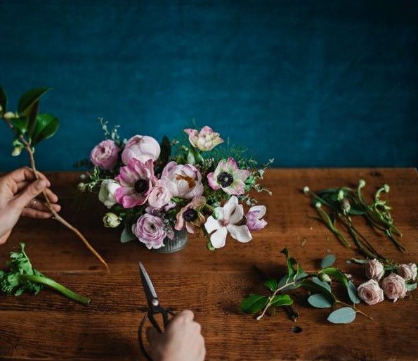 Hender som jobber med blomster. Foto.