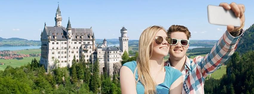 To ungdommer tar selfie foran et gammelt slott i skogen. Foto.