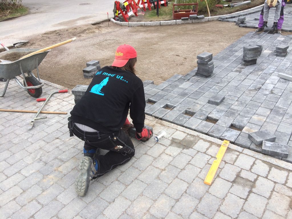 Anleggsgartnar legg belegningsstein. Foto.