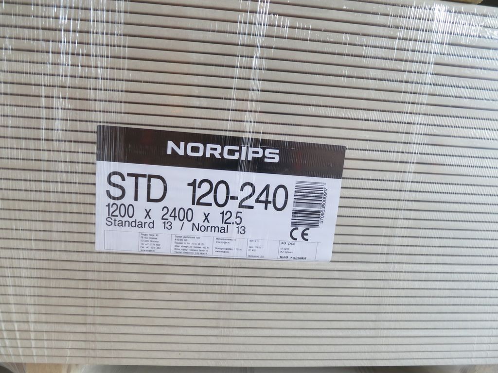 Gipsplater som er stabla, merkte og pakka inn i plast. Foto.