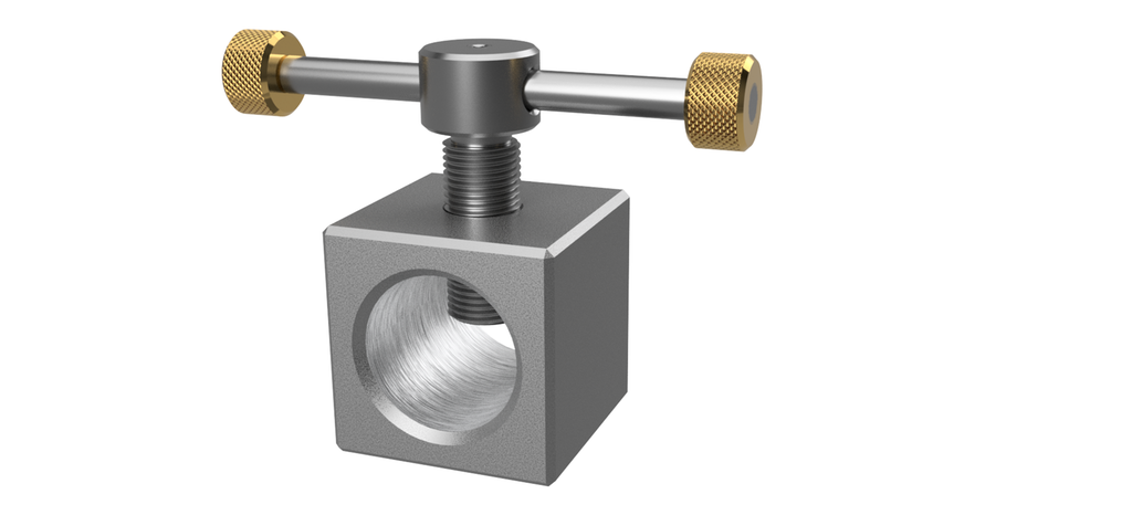 Sølvfarga, matt kloss med et hull tvers gjennom. Det går en sølvfarga skrue inn i klossen fra oversida. Håndtakene på skruen har gullfarga, runde klosser på endene. Illustrasjon.