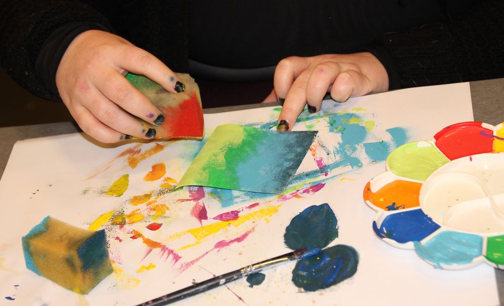 Hender maler med svamp. Foto.