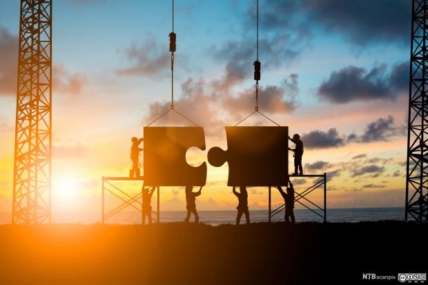 To store puslespillbiter settes sammen av små anleggsarbeidere. Illustrasjon.