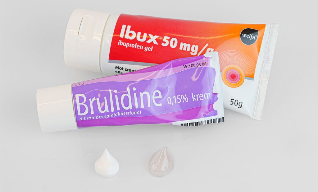 To tuber med gel og krem ved siden av hverandre. Foran tubene ligger det en dose hvit krem og en dose gjennomsiktig gel. Foto.