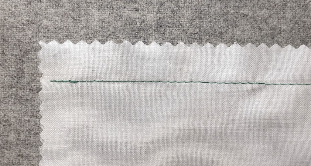 Fotografi av en hvit prøvelapp med en grønn rettsøm.