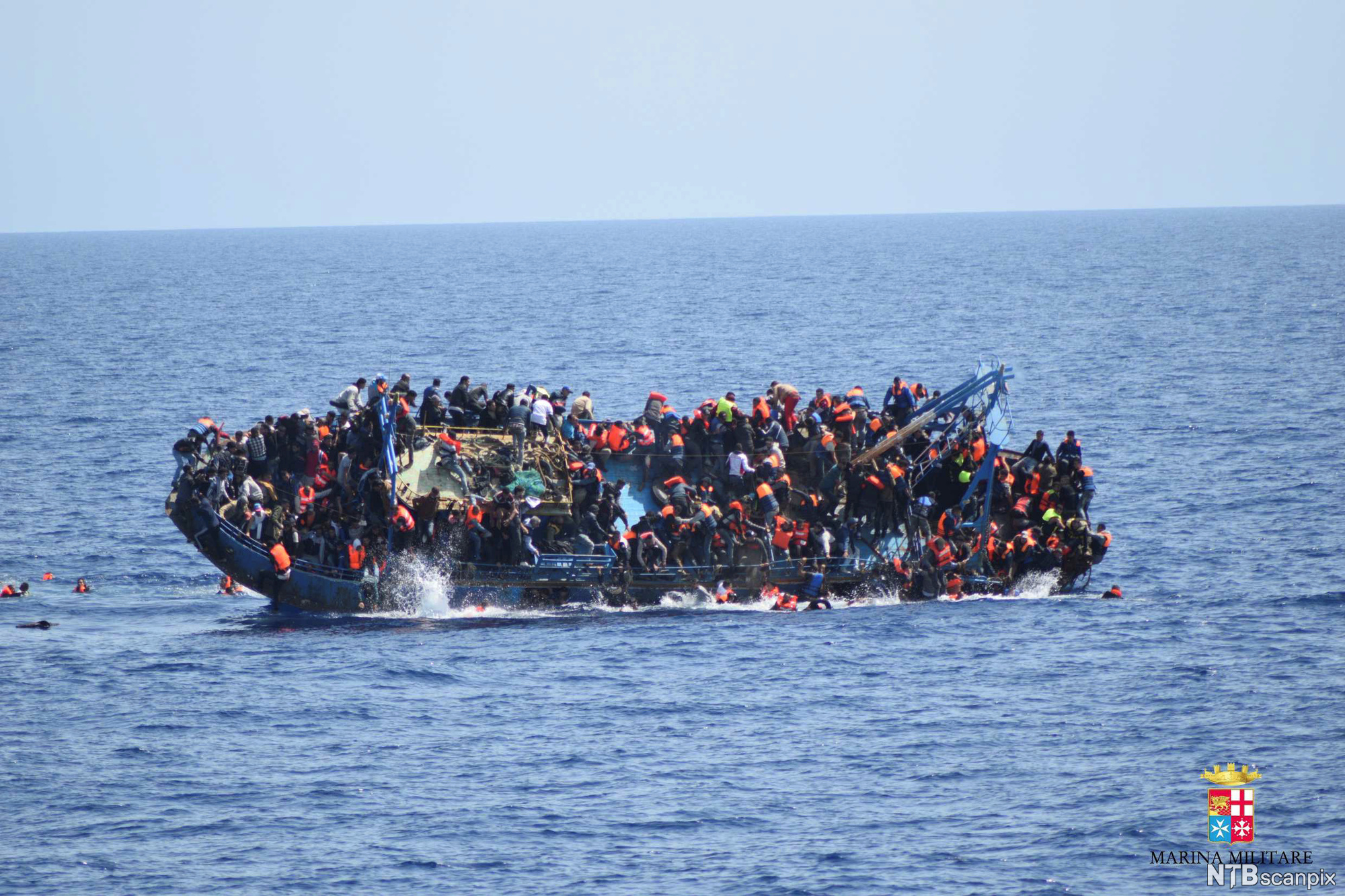 An overcrowded refugee boat capsizes in the Mediterranean Sea. Photo.