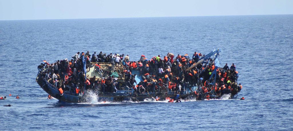 An overcrowded refugee boat capsizes in the Mediterranean Sea. Photo.