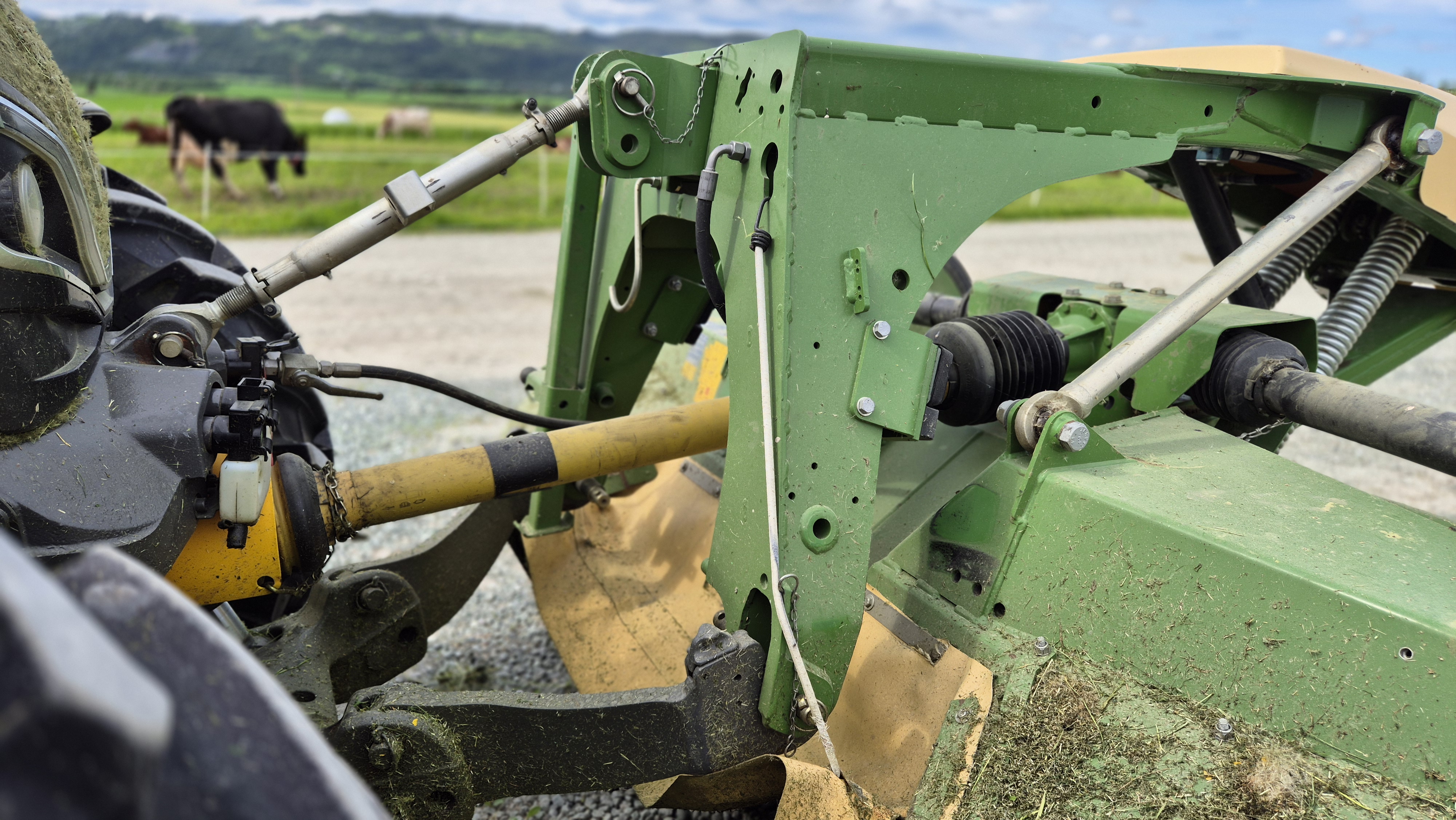 Kraftoverføringsaksling mellom traktor og slåmaskin. Det er et vernedeksel av plast rundt akslingen. Foto.