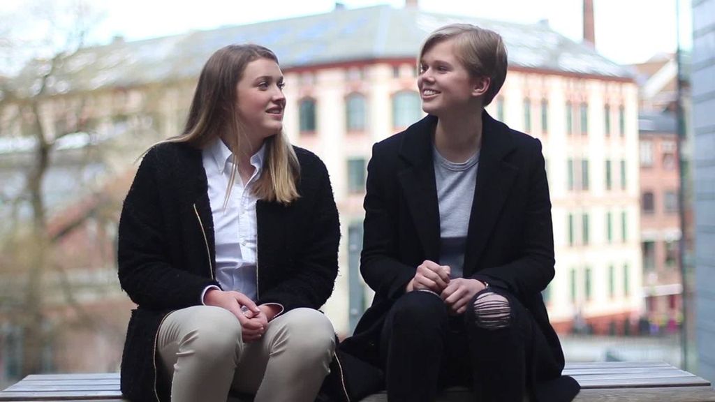 Julie Hausland Lundin og Emilie Byermoen, to tidligere elever ved Elvebakken videregående skole, sitter på en benk i nærheten av Akerselva i Oslo. Foto.
