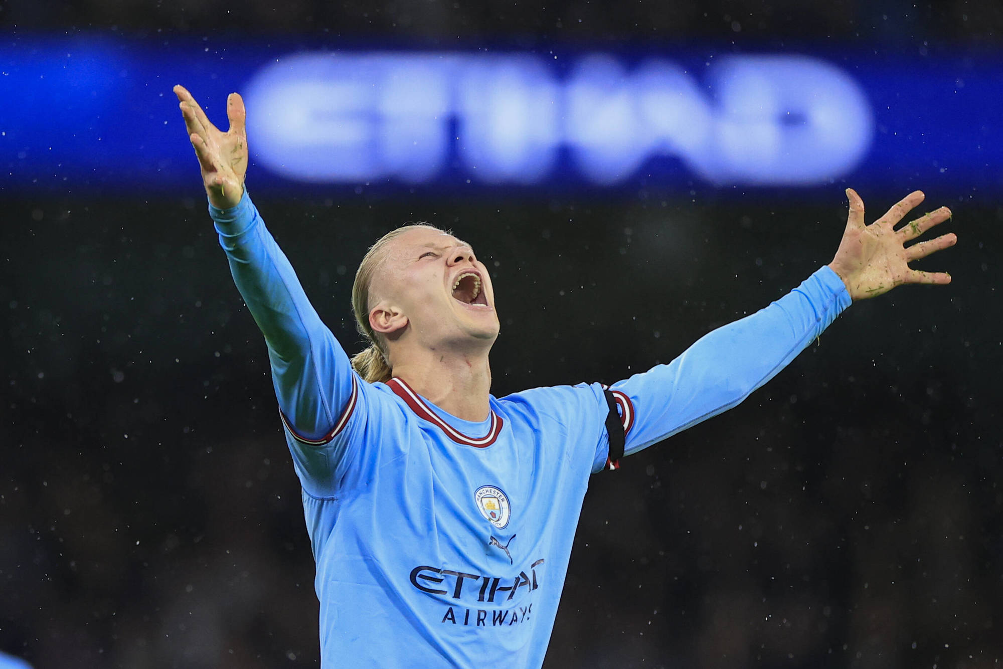 Fotballspilleren Erling Braut Haaland i Manchester City-drakt. Han strekker armene i været og roper mot himmelen. Foto.