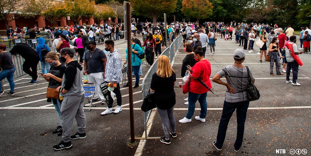 Photo: We see a lot of people standing in a parking lot.