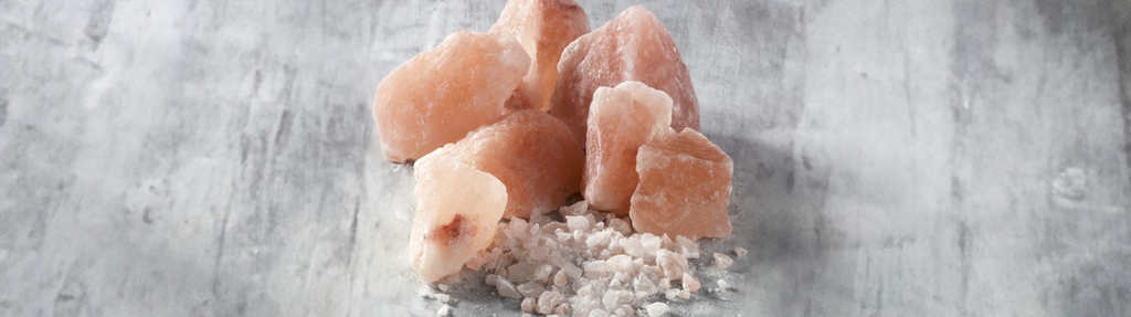 Store, lyst rosa saltkrystallar og grovmale rosa salt. Foto.